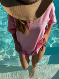 une fille sort d'une piscine avec un tshirt sunride studios rose